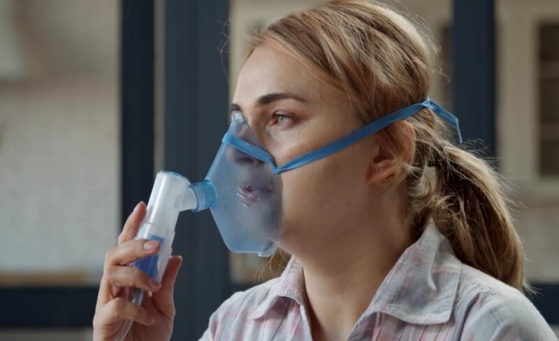 Woman inhaling from an inhaler